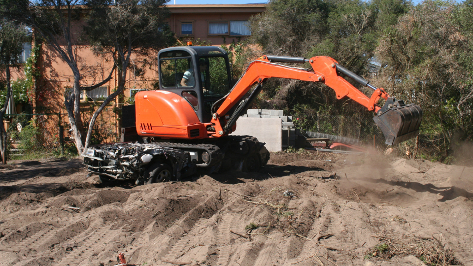 Excavator clearing land and digging